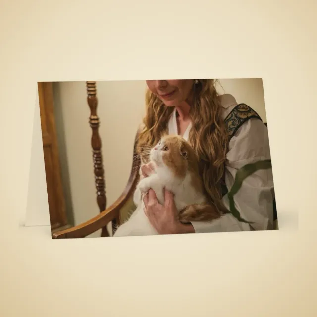 Carte de souhaits personnalisé : Femme aux cheveux bouclés tenant tendrement son chat dans un fauteuil